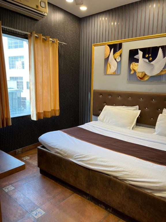 a bedroom with a large bed with a wooden headboard at Hotel Mannat Shalimar in New Delhi