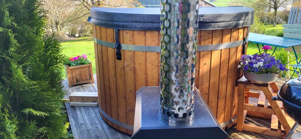 a hot tub sitting on a deck with a water fountain at Gîte La Fabrique bain nordique skadi privé & sauna , 7 chambres , tps de chauffe 1h30 in Les Fontenelles