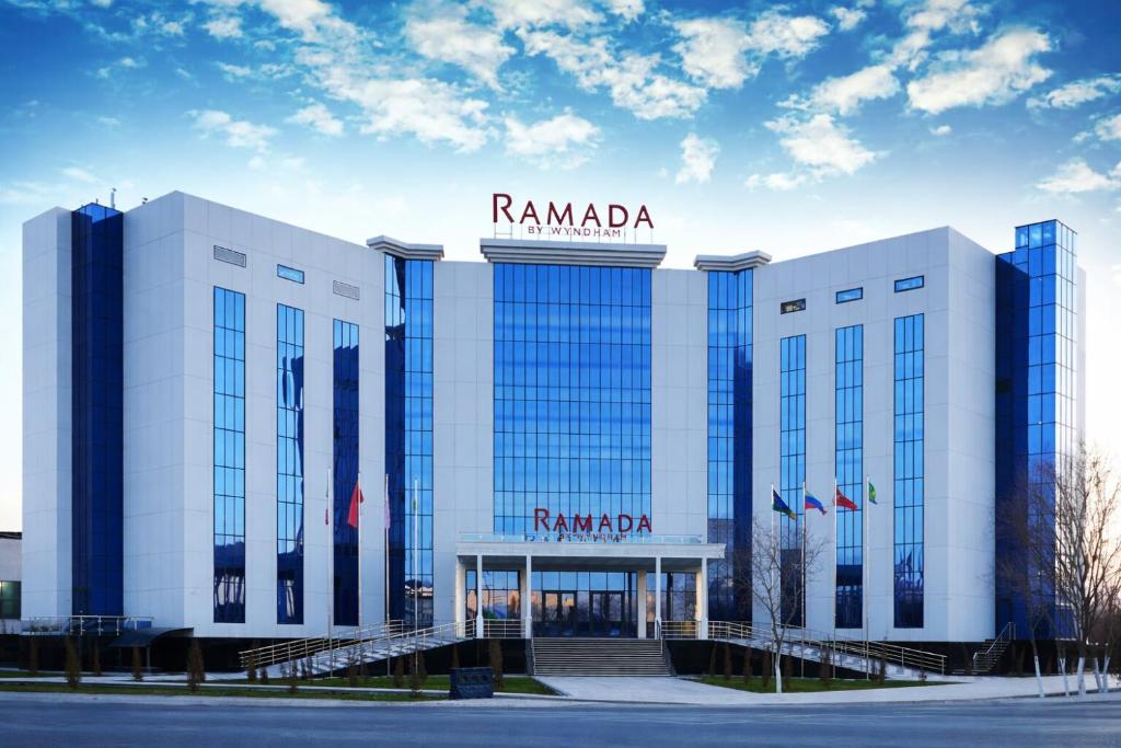 a building with a sign on top of it at Рамада Нукус in Nukus