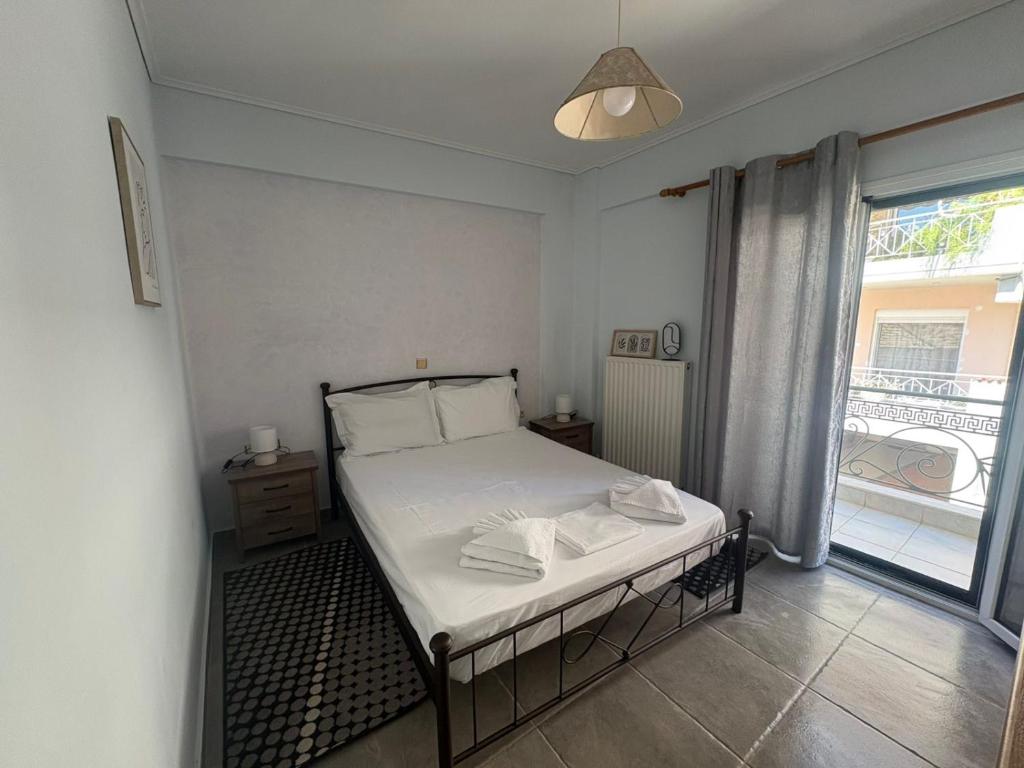 a bedroom with a bed and a large window at Chrisa's Apartments 1 in Missolonghi
