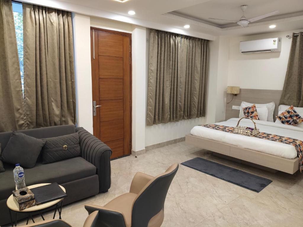 a hotel room with a bed and a couch at Gianmala Residency South Ex New Delhi in New Delhi