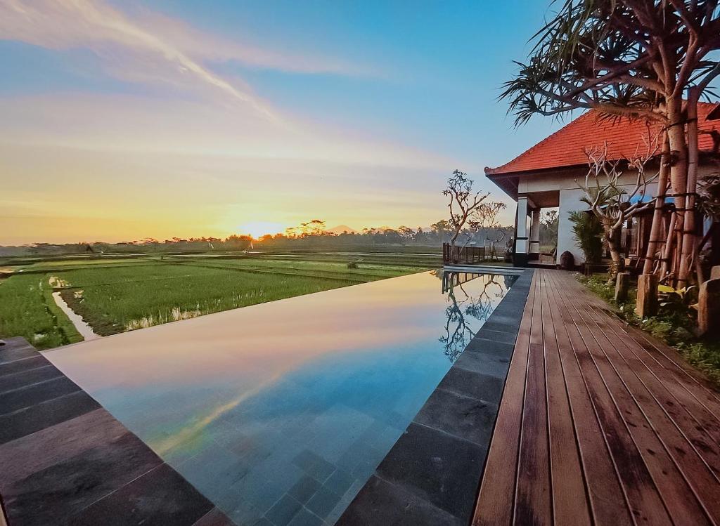 a house with a swimming pool next to a house at Umah Sunset in Ubud