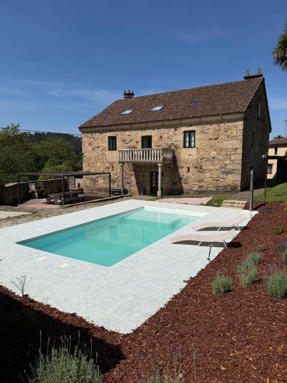 ein Schwimmbecken vor einem Steingebäude in der Unterkunft Casa Goris in Merza