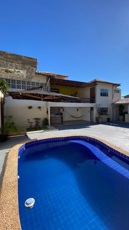 a blue swimming pool in front of a house at FamilySpace in Búzios