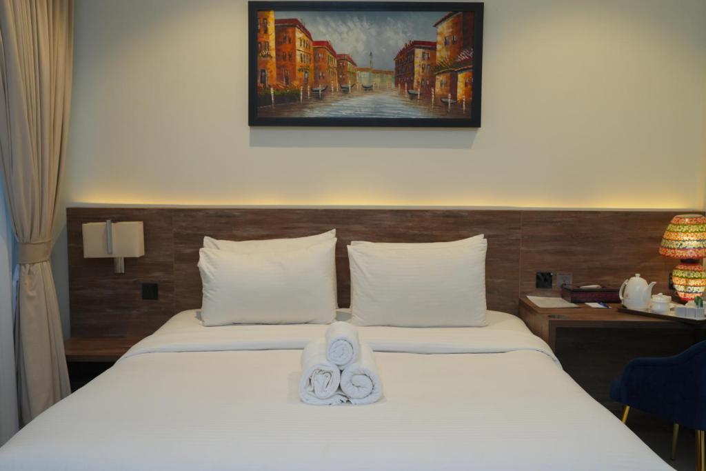 a hotel room with a bed with a towel on it at Sunset BnB Ramna Islamabad in Islamabad