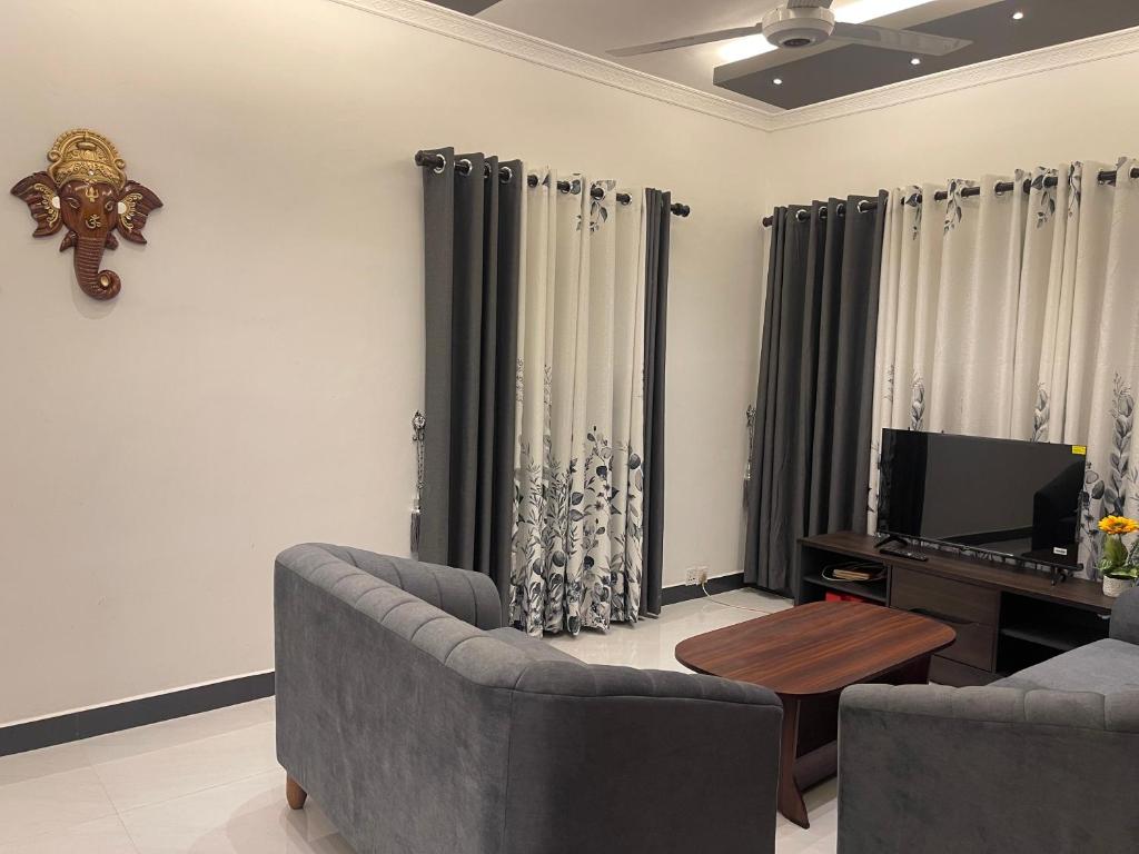 a living room with a couch and a tv at The Yarl Home in Jaffna