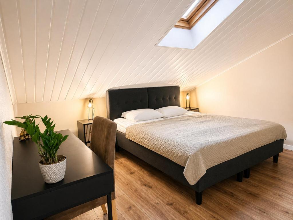 a bedroom with a bed and a table with a plant at Paruni Trahteri majutus in Viljandi