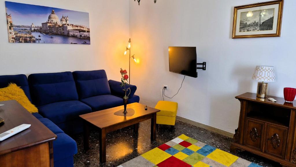 a living room with a blue couch and a table at Calle Bottari ChioggiaPL in Chioggia