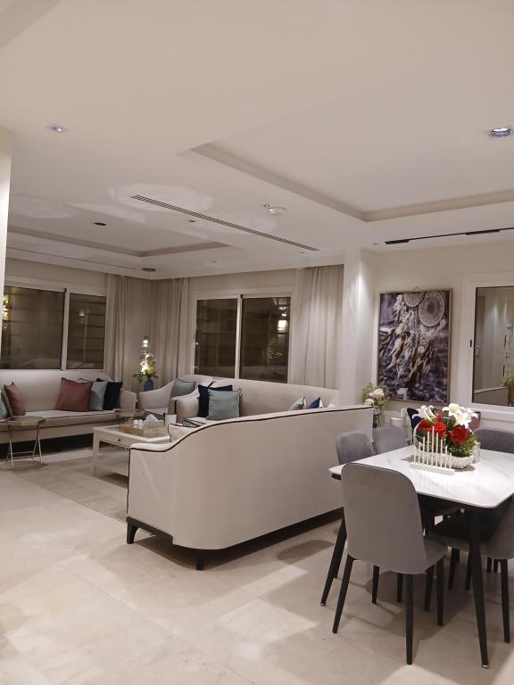 ein Wohnzimmer mit Sofas, Tisch und Stühlen in der Unterkunft دور ارضي كبير وواسع للضيافة والتحويل لحسابي بعد الوصول للمنزل in Riad