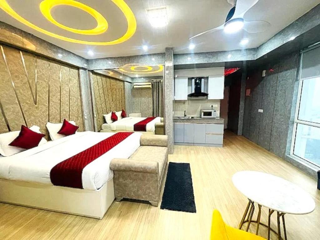 a bedroom with a large bed and a kitchen at Golden Pent House in Lucknow