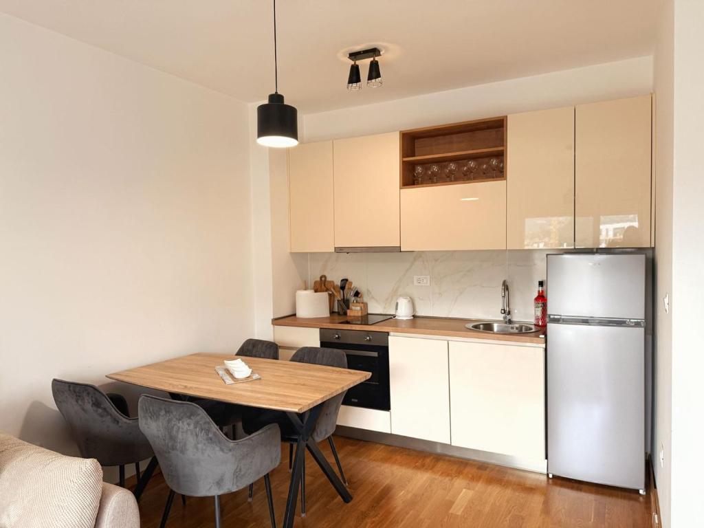 a kitchen with a wooden table and a refrigerator at Maison Budva in Bečići