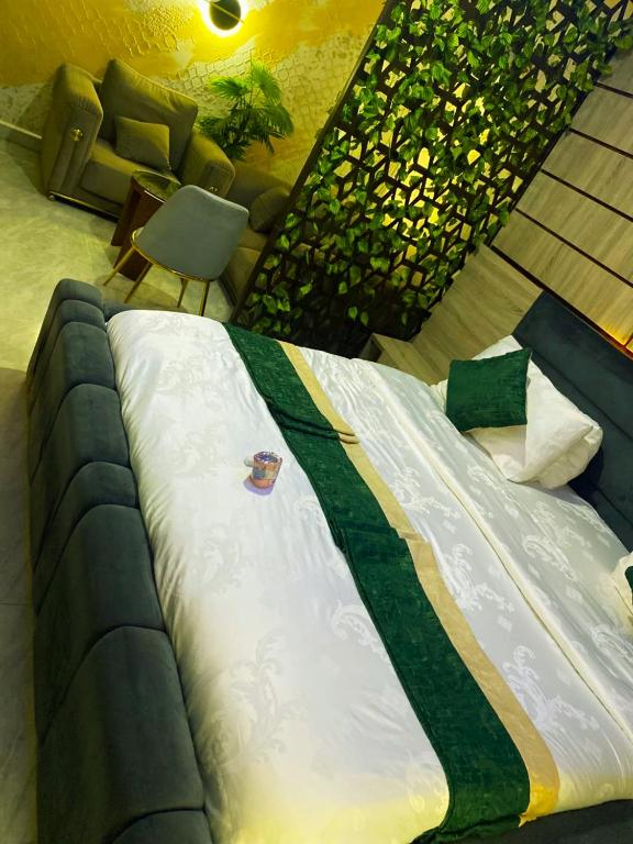 a large bed in a room with a couch at NH Norvits Hotel in Agbor