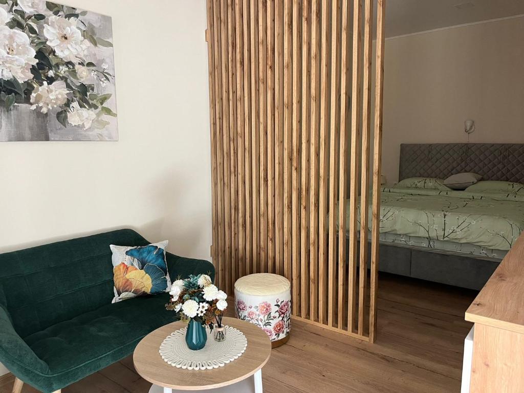 a living room with a green couch and a bed at Rooms Lami in Dubrovnik