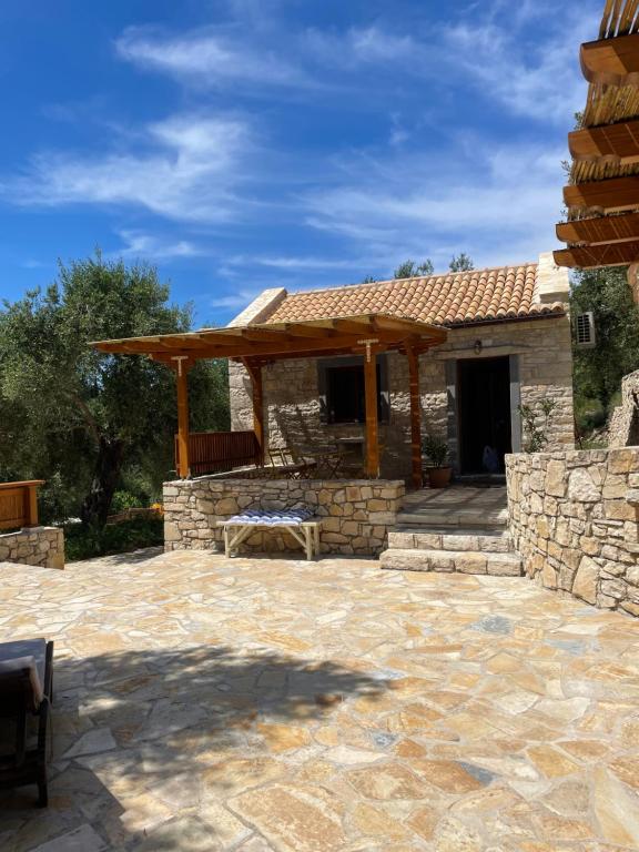 a large stone patio with a wooden pergola at Mikro kastro in Apergátika