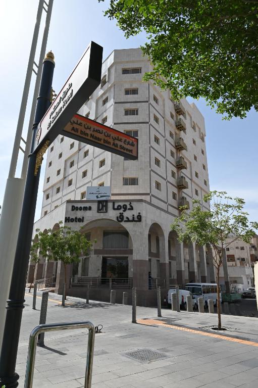 a pole with street signs in front of a building at فندق دوما - Domma hotel in Medina