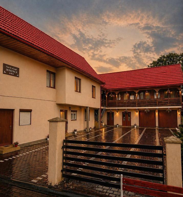 a building with a red roof and some stairs at Casa Marinca in Ocna Şugatag