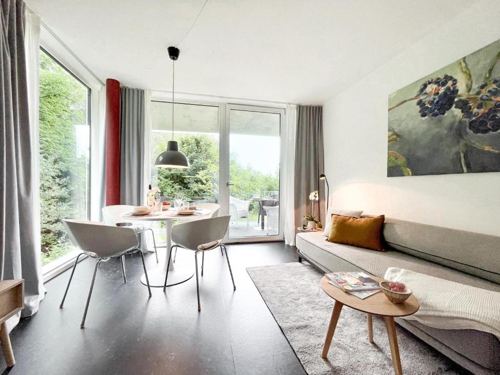 a living room with a bed and a table and chairs at Blueberry Living - Design-Apartments am Starnberger See, Natur & Erholung, Privatparkplatz, nur 400 m zum See in Tutzing
