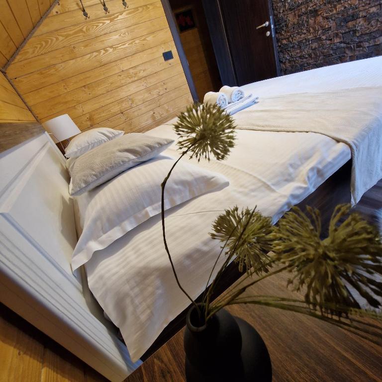 a bed with white pillows and plants on it at Cabana Tesa Borșa MM in Statjunea Borsa