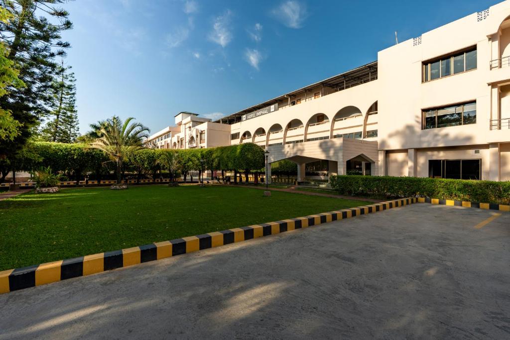 a large building with a lawn in front of it at Hotel Imphal by the Classic in Imphal