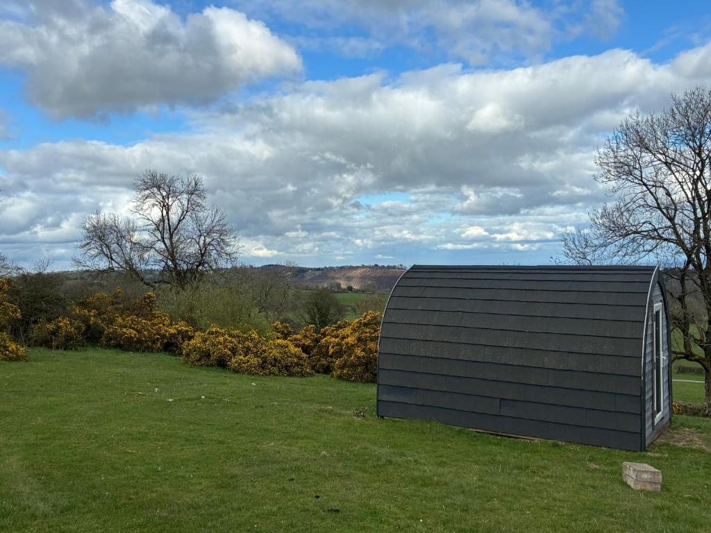 a building in the middle of a field at Hillside Pod in Oswestry