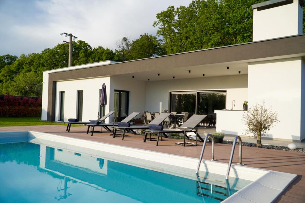 a house with a swimming pool next to a house at Villa Tomaté in Velika Buna