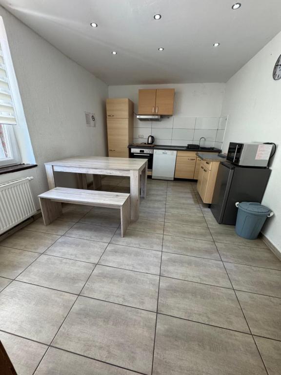 a kitchen with a table and a bench in it at Ferien- und Monteurunterkunft Alsdorf 2 in Alsdorf