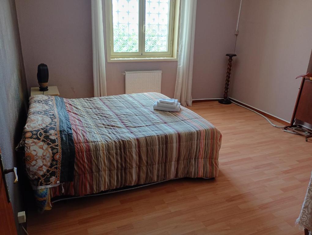 a bedroom with a bed with a blanket and a window at Santi Palace Apartment in Gravina di Catania
