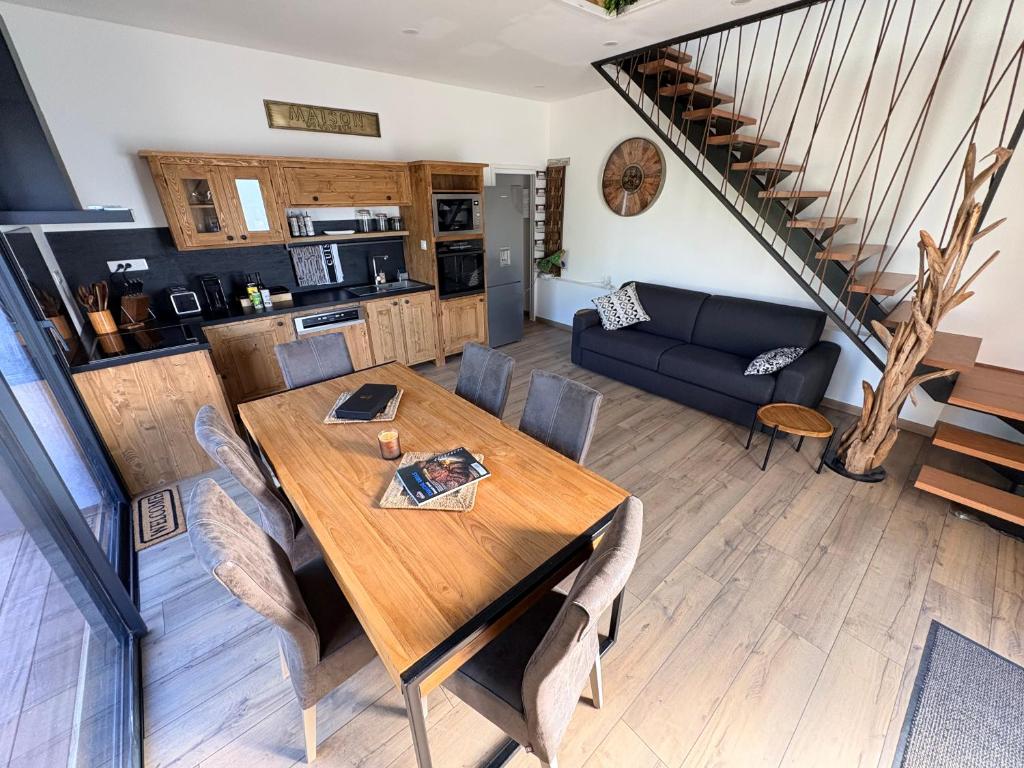 a dining room and living room with a wooden table at L Amy-Côtier in Saint-Pierre-dʼOléron
