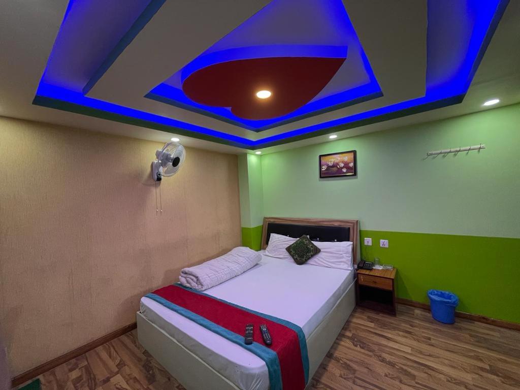 a bedroom with a bed with a blue ceiling at Hotel Best Ocean in Kathmandu