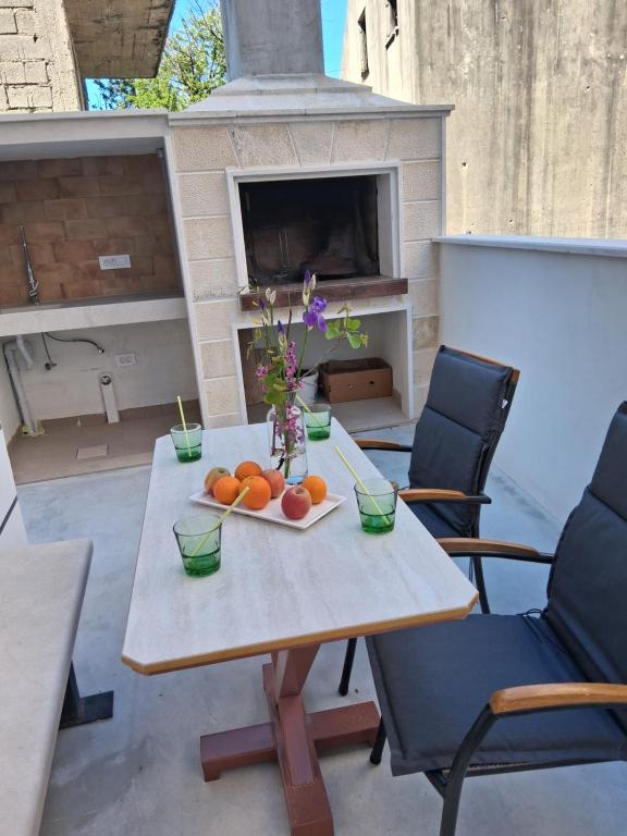 a table with oranges and flowers on a patio at Apartman Golden Stone in Ivanica