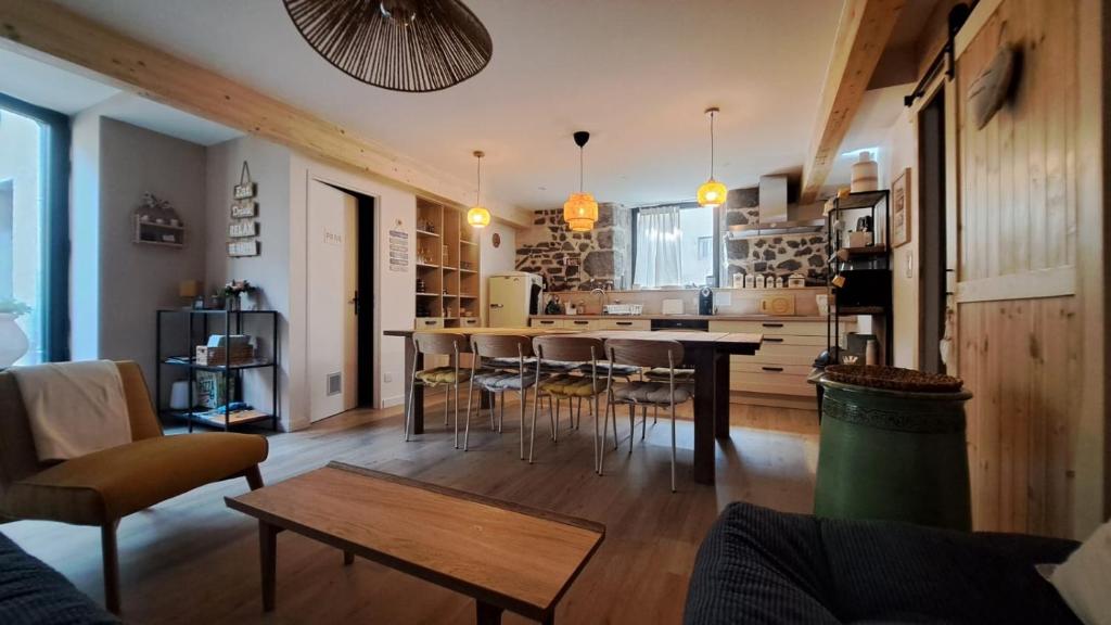 a kitchen and living room with a table and chairs at En si bon chemin - Gîte d'étape chemin 70 in Le Monastier sur Gazeille