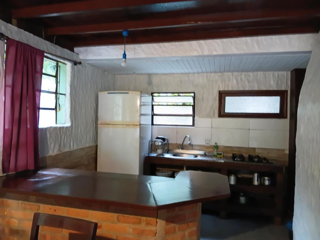 a kitchen with a refrigerator and a sink at Apartamentos do Centrinho do Rosa in Imbituba