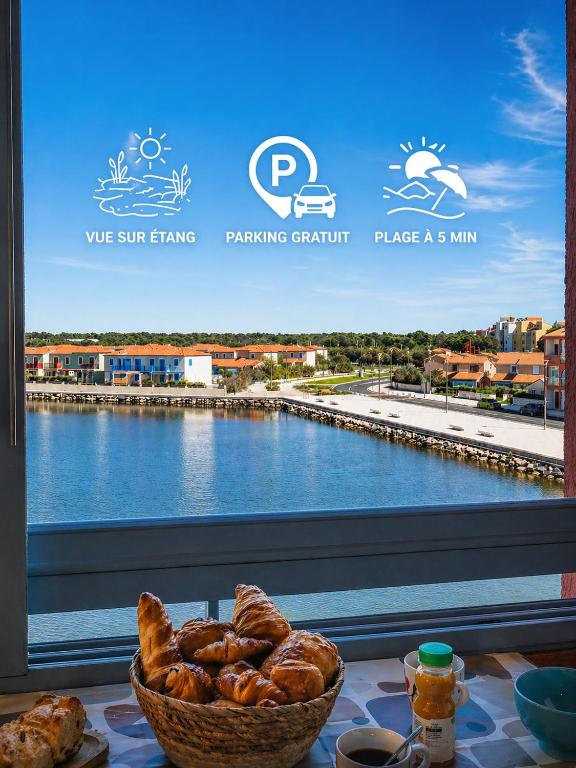 a basket of bread sitting on a table next to a window at L'Horizon Bleu - Vue Etang - Parking - Plage à 5 min in Le Barcarès