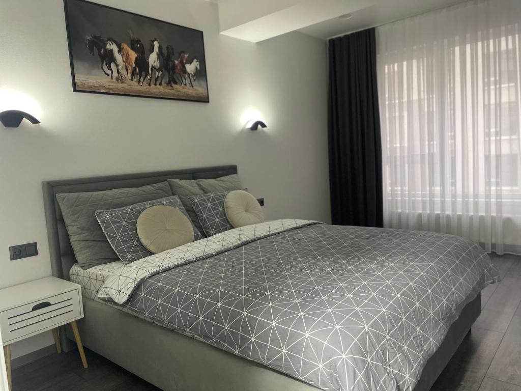 a bedroom with a bed with a gray comforter at Modern Apartment in Chişinău