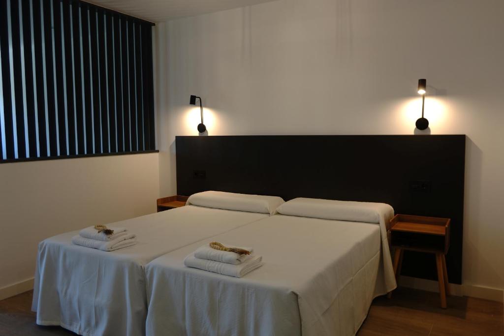 a bedroom with a bed with two towels on it at IG Apartamentos in Palas de Rei