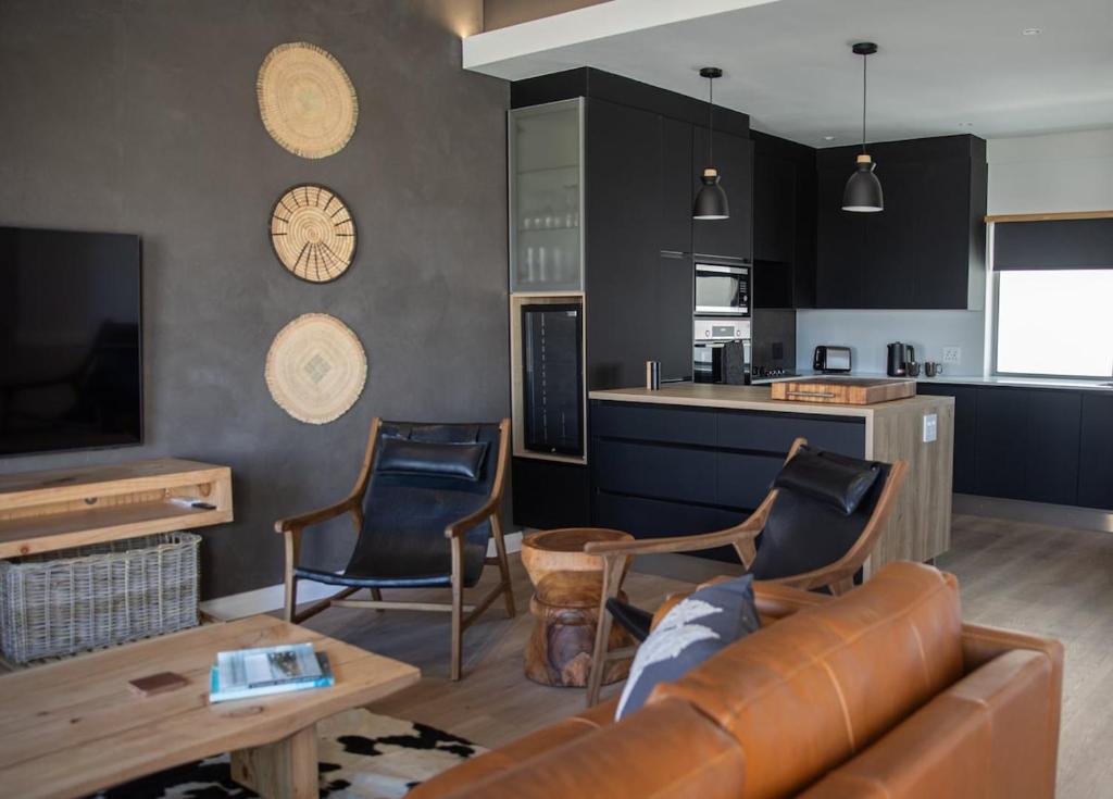 a living room with a couch and chairs and a kitchen at PenthouseOne on the Canals in Marina Glades