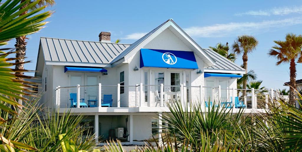 a white house with a blue sign on it at Inn on the Beach in St. Pete Beach