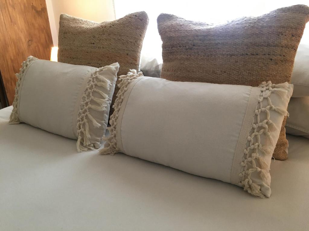 a group of pillows sitting on top of a bed at Casa Del Fogón, En La Calle Del Castillo in Vejer de la Frontera