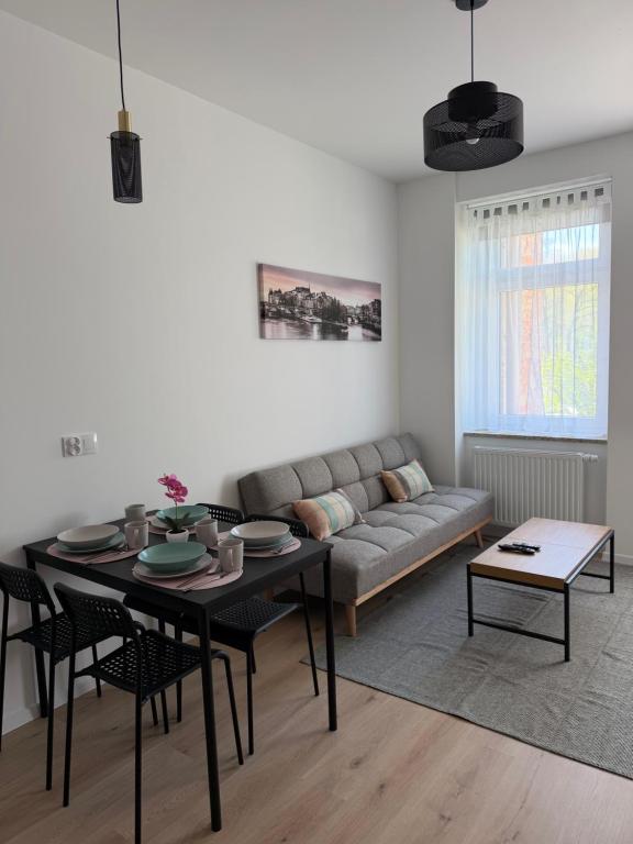 a living room with a couch and a table at Apartament between the bridges II in Zgorzelec