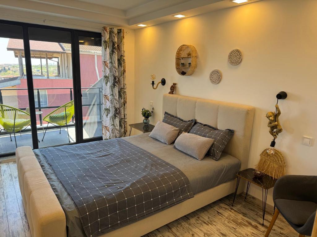 a bedroom with a bed and a balcony at Киво апарт Созопол in Sozopol