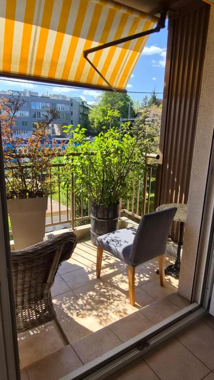 a view of a balcony with a chair and an umbrella at Sunny Place Geneva 15 min Train in Versoix
