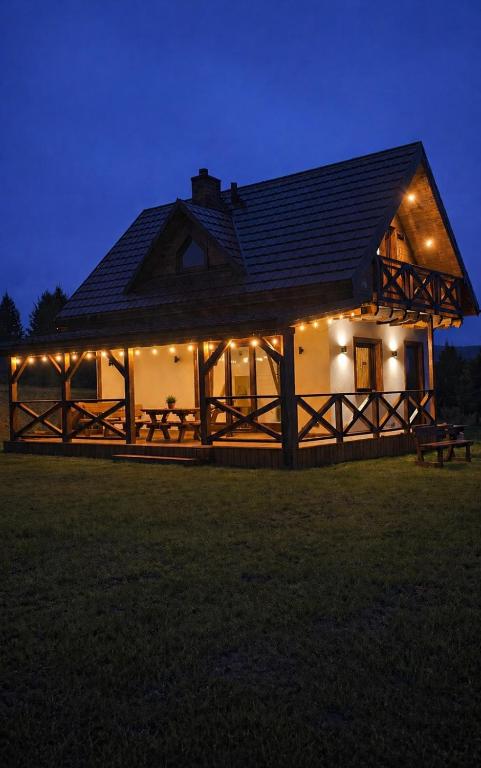 a large house with lights on it at night at Domek Pod-Górski in Baligród
