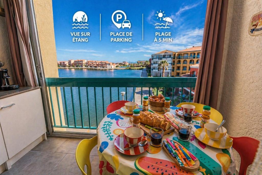a table with food on it with a view of the water at Escapade Marine - Vue Etang - Place de parking privé - Plage à 5 min in Le Barcarès