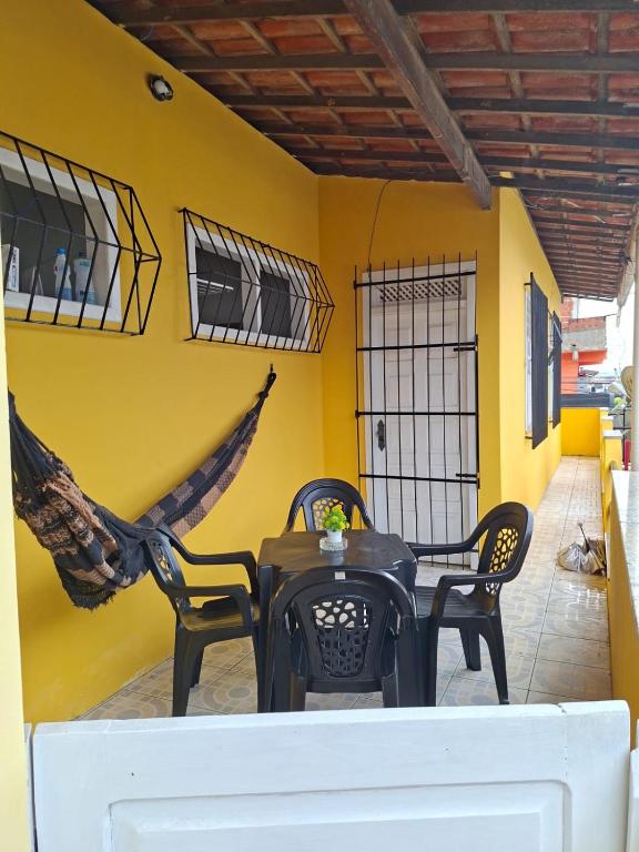 a table and chairs in a room with a yellow wall at Apartamento Day in Ilhéus