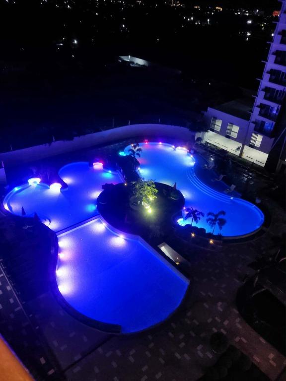an overhead view of three pools at night at Primeworld District Condo in Agus