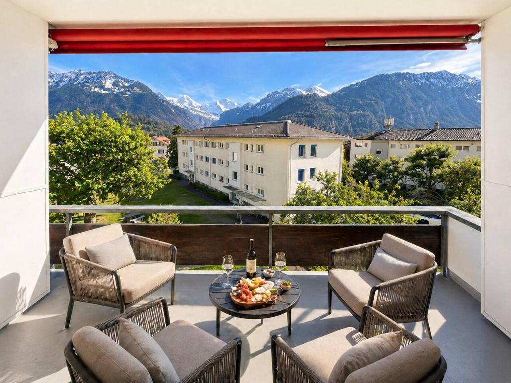 a balcony with chairs and a table and a view of mountains at 3Br Topview Interlaken Mountain View Apartment in Unterseen