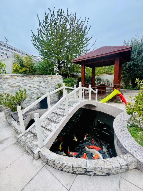 a koi pond with a bridge and a gazebo at Maisonnette au calme-proche Métro in Maisons-Alfort