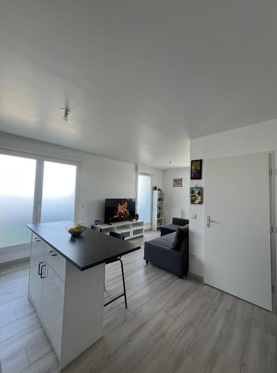 a living room with a table and a couch at T2 cosy proche Versailles in Trappes