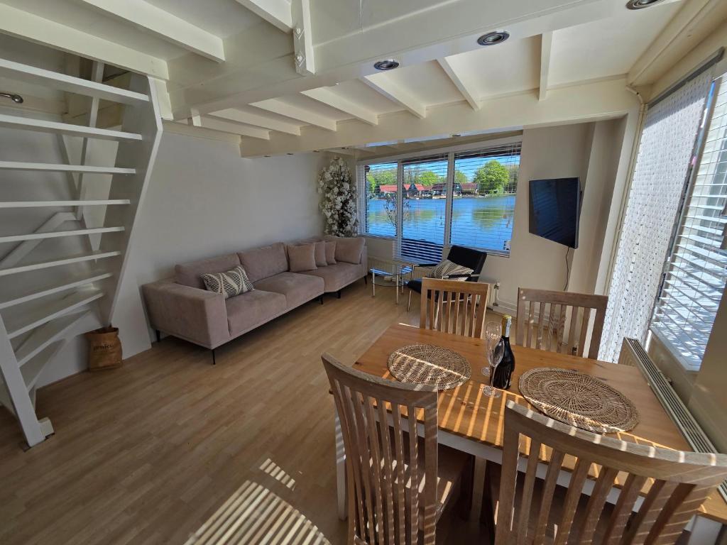 a living room with a table and a couch at View at the Lake in Nieuwe-Niedorp