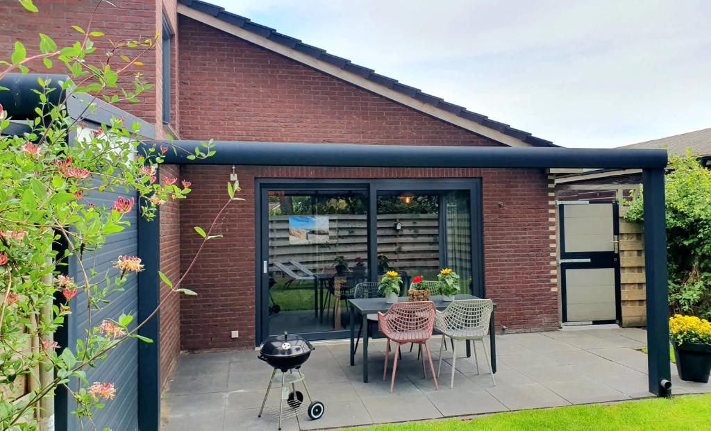 a patio with a table and chairs on it at Luxe vakantiehuis met omheinde tuin voor hond en kinderen in Dirkshorn